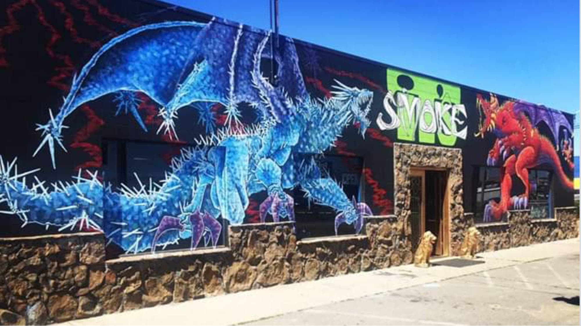 The painted dragon mural across the front of Smokeits Smokeshop on 2308 S 1st St